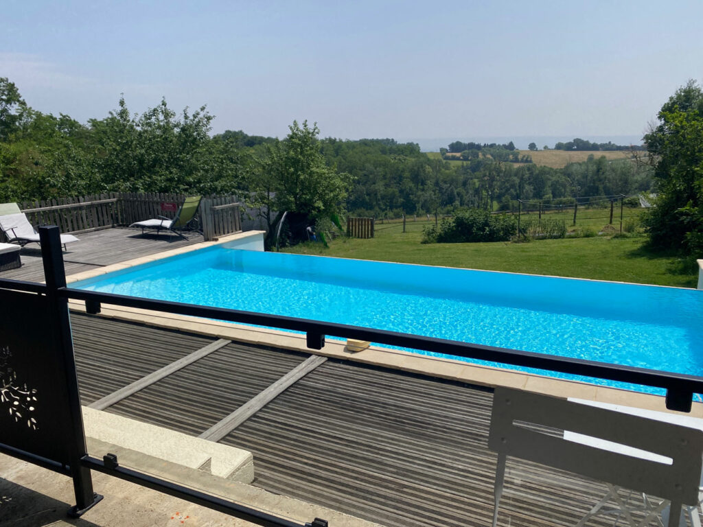 Vue sur une partie de la terrasse et de la piscine à débordement.